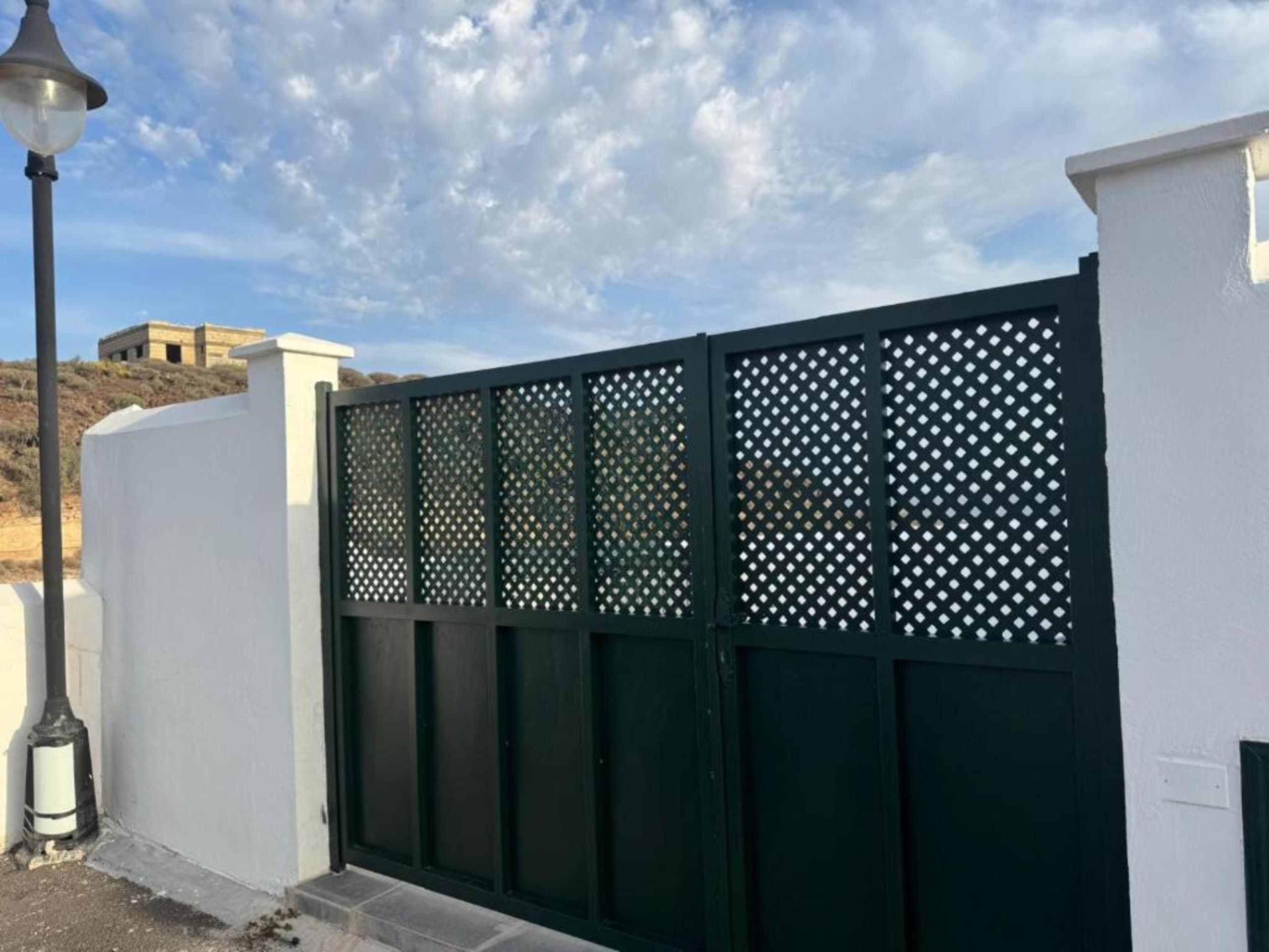 Acceso privado seguro con portón decorativo de diseño moderno. Entrada exclusiva a Vidamar con estilo contemporáneo y privacidad garantizada para tu estancia.